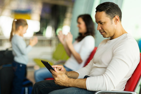man using tablet computer at airport