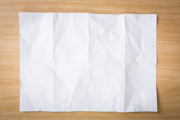 White crumpled paper on a wooden desk