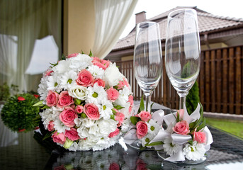 Wedding. Bridal bouquet and wine glasses on a table.