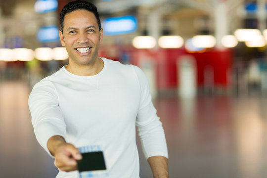 man handing over air ticket at check in counter