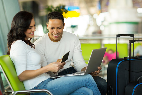 couple checking flight information on laptop