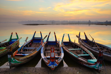 Fototapeta na wymiar Wooden boat in Ubein Bridge at sunrise, Mandalay, Myanmar
