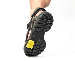 Men's foot in sandals on a white background