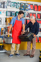 Salesman Assisting Man In Selecting Toolbox At Store