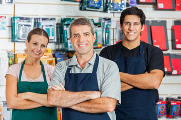 Salespeople Standing Arms Crossed In Hardware Shop