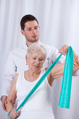 Physiotherapist exercising with elderly patient