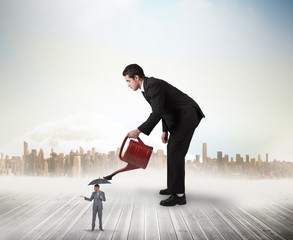 Composite image of businessman watering tiny business team © WavebreakMediaMicro