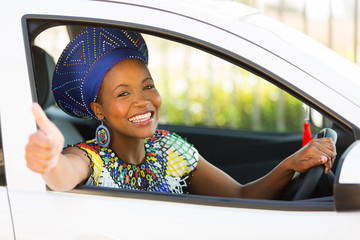 south african woman giving thumb up inside her car