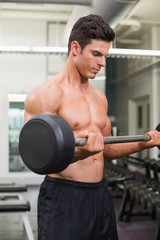 Shirtless muscular man lifting barbell