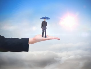 Composite image of businessman holding umbrella