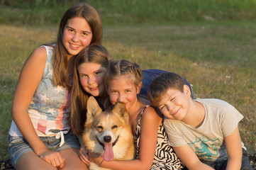 Outdoor portrait of group of teenagers with the dog.