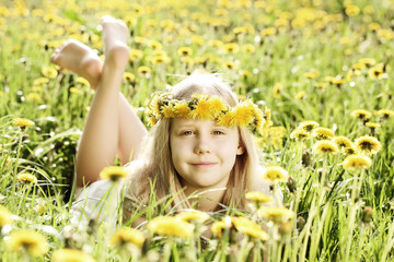 Cute little girl on sunny lighting background of green grass and