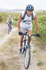 Fototapeta na wymiar Fit attractive couple cycling on mountain trail