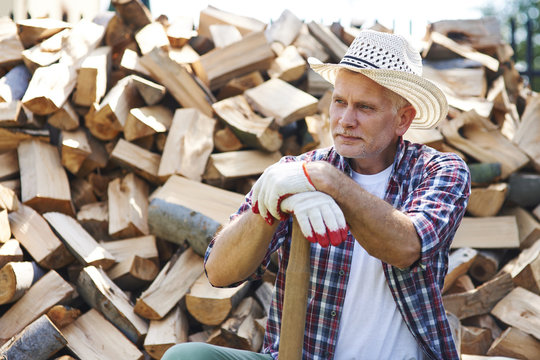 Mature lumberjack resting after splitting wood