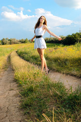 Fototapeta na wymiar young happy girl walking in meadow