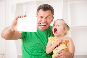 Father and child using electronic tablet at home