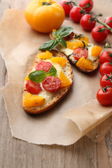 Tasty bruschetta with tomatoes, on old wooden table