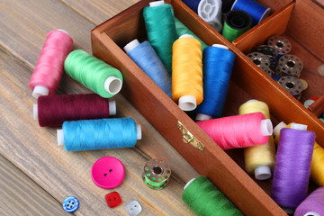 Colorful threads for needlework in wooden box close up