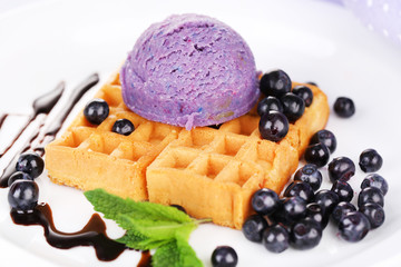 Tasty belgian waffles with ice cream on wooden table