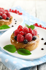 Sweet cakes with berries on table close-up
