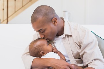 Happy father spending time with baby on the couch