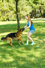 Beautiful young girl with dog in park