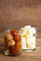 Iced coffee and milky cubes in glass on wooden background