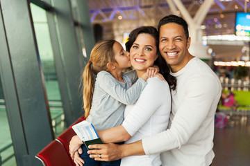 little girl kissing her mother at airport