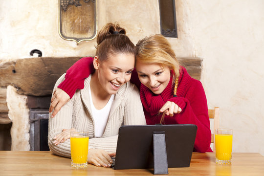 Two beautiful women work on the tablet
