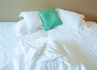 Fototapeta na wymiar pillows and white sheets on messy bed