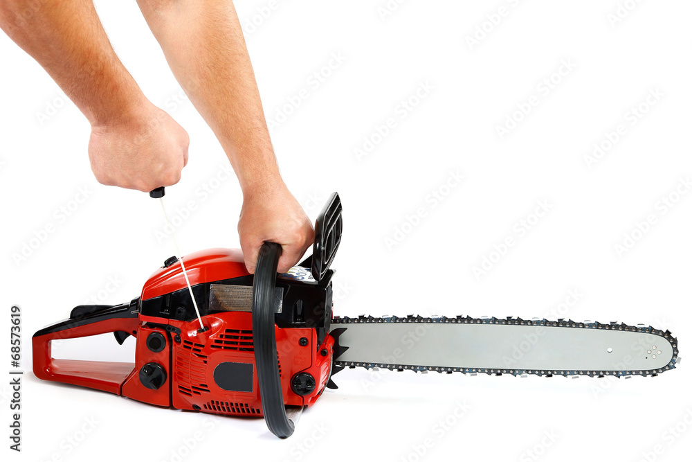 Wall mural Gasoline chain saw in hand on a white background.