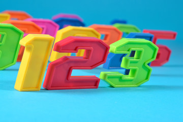 Colorful plastic numbers 123 on a blue background
