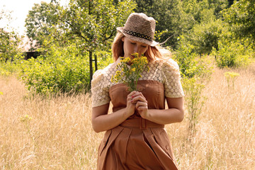 Frau riecht an Blumen