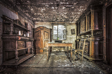 Fototapeta na wymiar Decayed dining room in an abandoned house