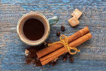 Cup of coffee and spices on vintage wooden background