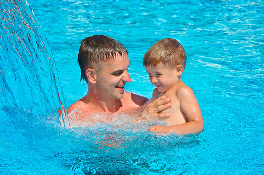 Father and son having fun in the pool