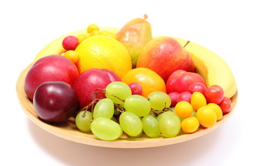 Fresh ripe fruits on wooden plate