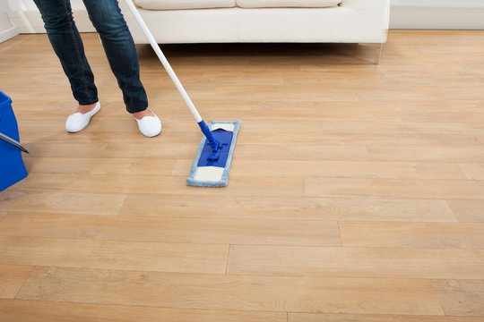 Woman Mopping Hardwood Floor At Home