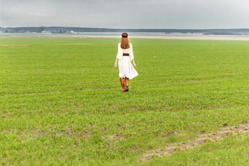 Fototapeta na wymiar beautiful girl in a white dress on the field