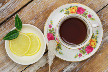 Black tea in vintage cup on wooden surface