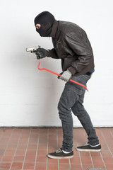 Einbrecher mit Waffe und Brechstange