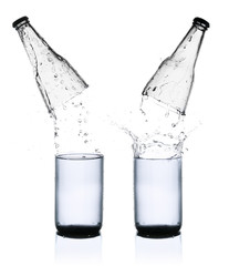 Fresh water splashing out of bottle, isolated on white backgroun