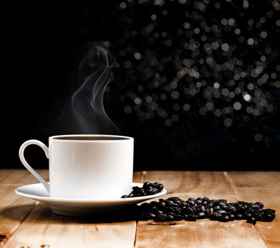 White coffee cup on wooden table and dark background
