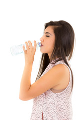 Beautiful young girl drinking water from a plastic bottle