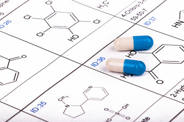 pills on chemical structure formula background
