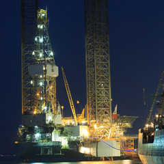 Jack up oil drilling rig in the shipyard in the evening