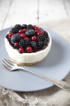 mini cheesecake with red fruits on plate with fork