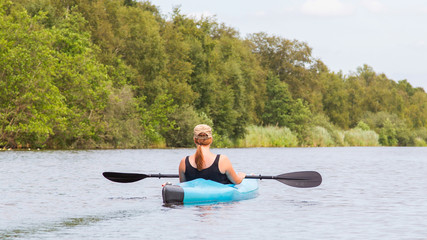 Woman on a small river in rural landscape