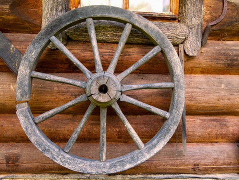 Hand spinning wheel on  wall of  old log house