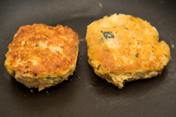 Two Crab Cakes Cooking in Saute Pan